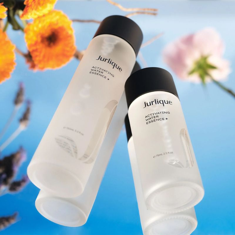 Two bottles of Jurlique Activating Water Essence with flowers in the background