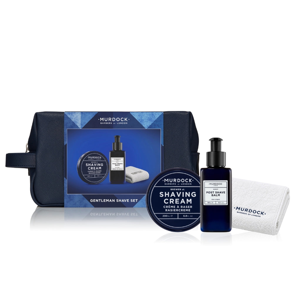 Murdock Gentleman Shave Set including a navy blue zippered travel pouch, shaving cream jar, dark blue pump bottle of Post Shave Balm, and a white microfiber towel, arranged on a white background.